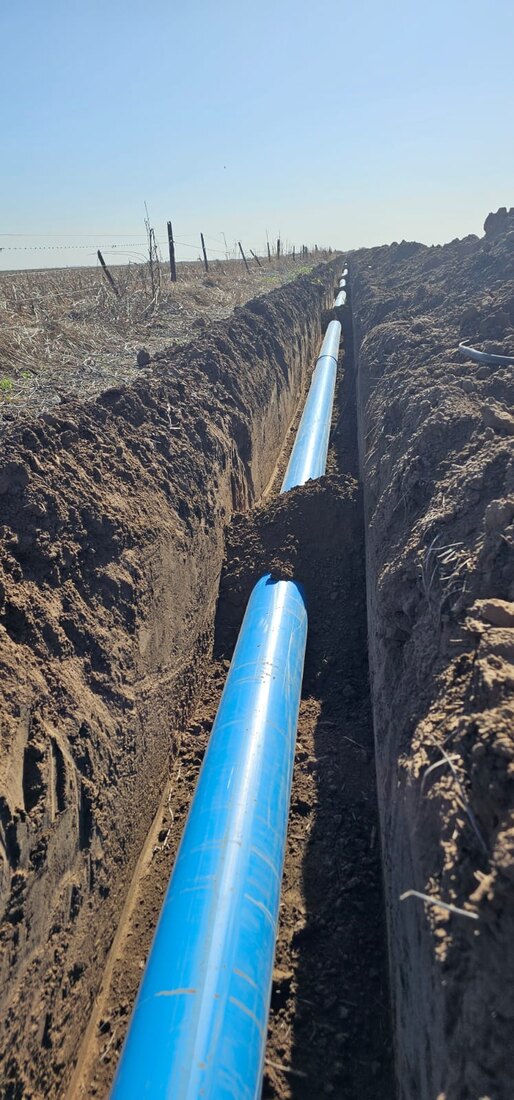 Cañería de PVC instalada en una zanja larga en el campo